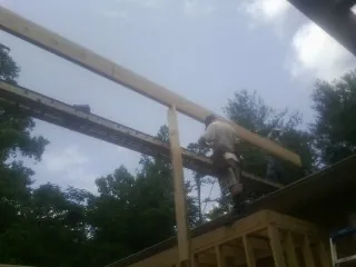 Carpenter setting a ridge beam over a new addition frame — Ice Dam Removal by Roofing Brothers in Dawsonville