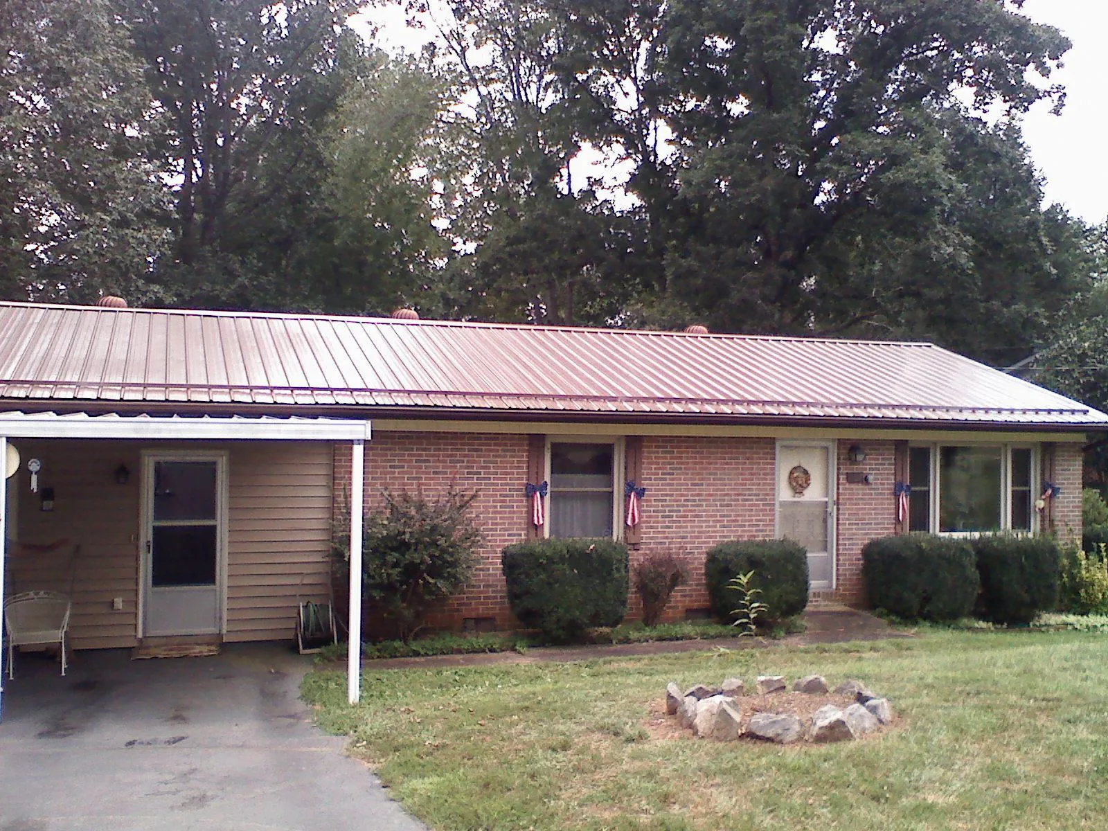Bronze metal roof and carport on a brick ranch home — Roof Repair work by our crew in Dawsonville