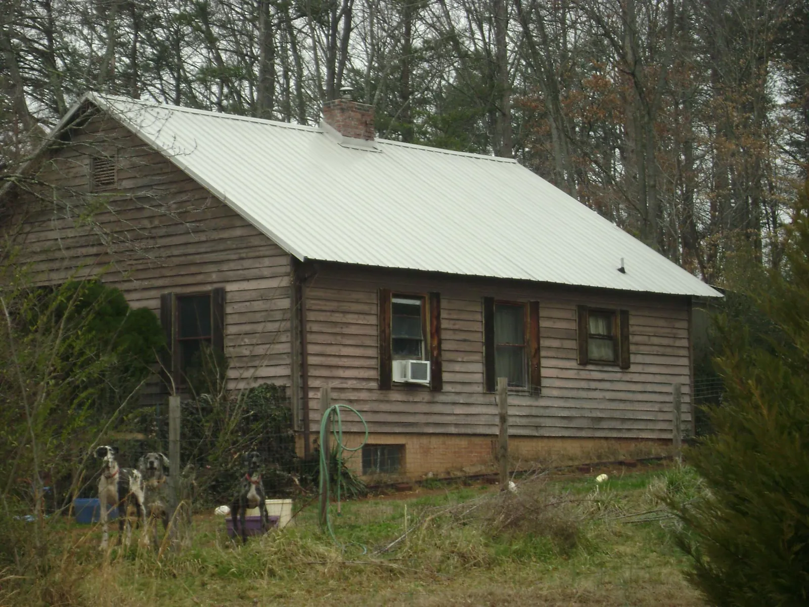 White metal roof on an old wood sided farmhouse, from a Metal Roof Installation job in Dawsonville